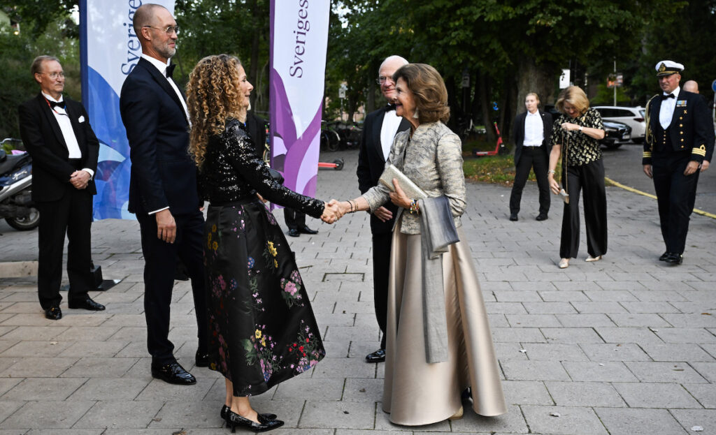 Johan Sidenmark, Sveriges Radios styrelseordförande, och Cilla Benkö, vd Sveriges Radio, välkomnar kung Carl Gustaf och drottning Silvia när de den 19 september 2025 anländer till jubileumskonserten på Berwaldhallen med anledning av att Sveriges Radio fyller 100 år